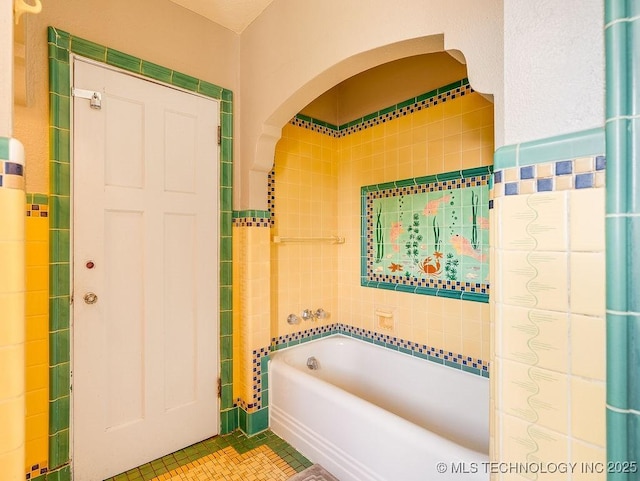 bathroom with tile patterned flooring and tile walls