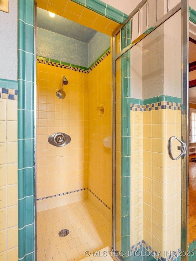 bathroom with a shower stall and tile patterned floors