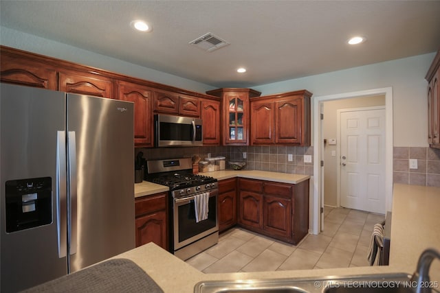 3983 S 216th E Ave, Broken Arrow, OK 74014 - kitchen featuring stainless steel appliances, light countertops, light tile patterned floors, glass insert cabinets, and recessed lighting