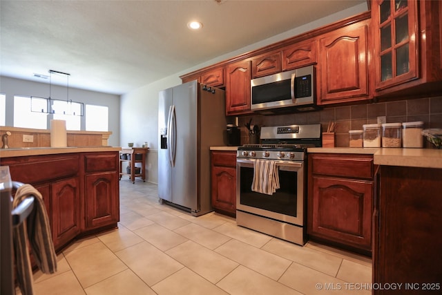3983 S 216th E Ave, Broken Arrow, OK 74014 - kitchen with stainless steel appliances, light countertops, glass insert cabinets, recessed lighting, and pendant lighting
