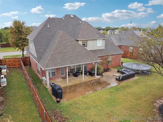 rear view of house with brick siding, an outdoor hangout area, a shingled roof, and a patio area