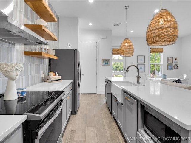 40 Center Ln N, Carlton Landing, OK 74432 - kitchen featuring open shelves, wall chimney range hood, appliances with stainless steel finishes, gray cabinetry, and light countertops