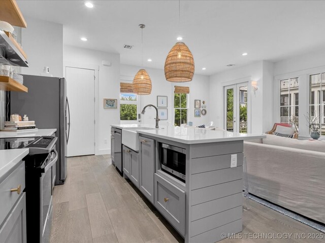 40 Center Ln N, Carlton Landing, OK 74432 - kitchen with gray cabinetry, appliances with stainless steel finishes, open shelves, french doors, and light wood-style floors