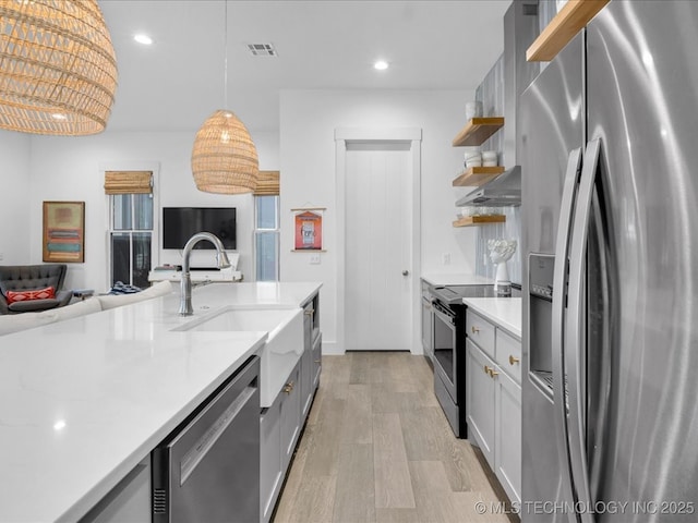 40 Center Ln N, Carlton Landing, OK 74432 - kitchen with stainless steel appliances, open shelves, light wood finished floors, light countertops, and open floor plan