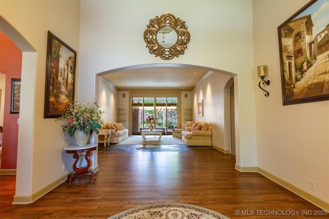 3107 E 88th St, Tulsa, OK 74137 - corridor with wood finished floors, arched walkways, baseboards, a towering ceiling, and crown molding