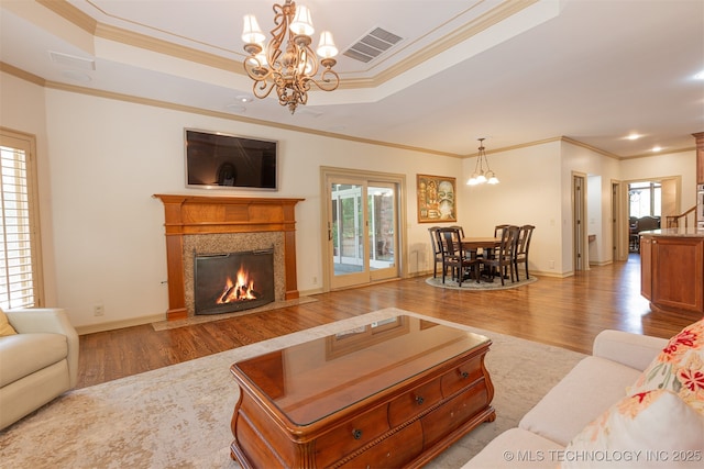 3107 E 88th St, Tulsa, OK 74137 - living room with wood finished floors, a chandelier, healthy amount of natural light, crown molding, and a raised ceiling