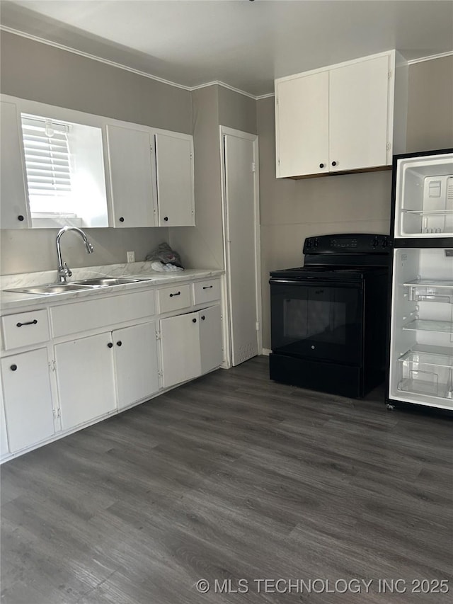 909 W Arkansas St, Durant, OK 74701 - kitchen with black electric range oven, a sink, white cabinets, dark wood-style floors, and crown molding