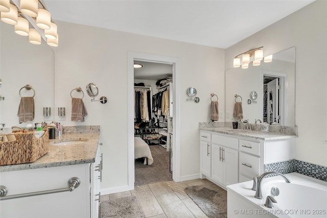 5412 E 122nd St S, Bixby, OK 74008 - full bath featuring two vanities, a tub, a walk in closet, and baseboards