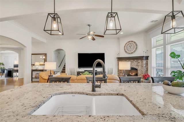 5412 E 122nd St S, Bixby, OK 74008 - kitchen with a sink, arched walkways, light stone counters, ceiling fan, and crown molding