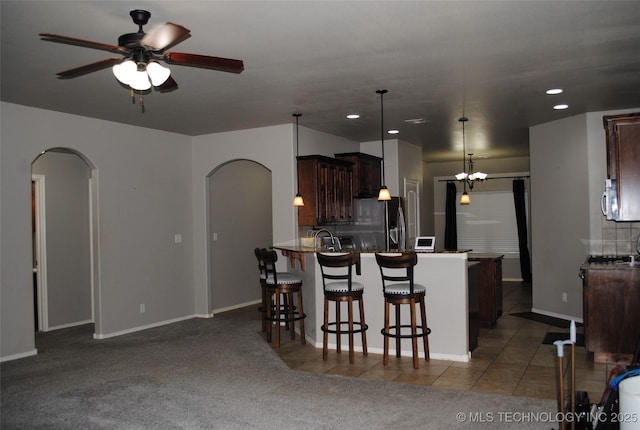 2025 E 134th St S, Bixby, OK 74008 - kitchen with arched walkways, a ceiling fan, fridge with ice dispenser, recessed lighting, and a breakfast bar area