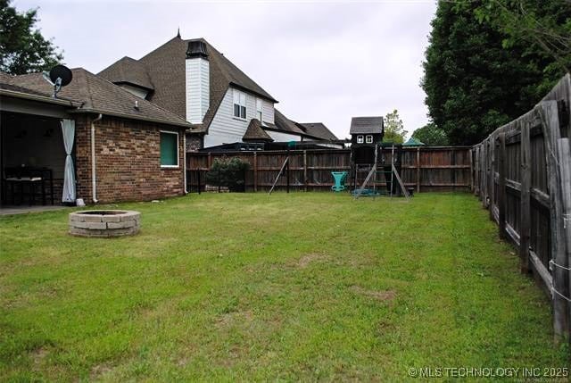 2025 E 134th St S, Bixby, OK 74008 - fenced backyard featuring an outdoor fire pit and a playground