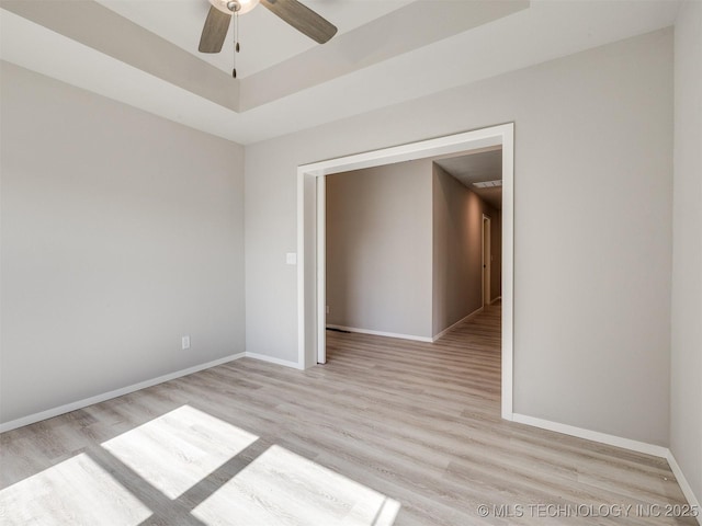 13402 E 124th St, Collinsville, OK 74021 - unfurnished room with light wood-style flooring, a ceiling fan, baseboards, and a tray ceiling
