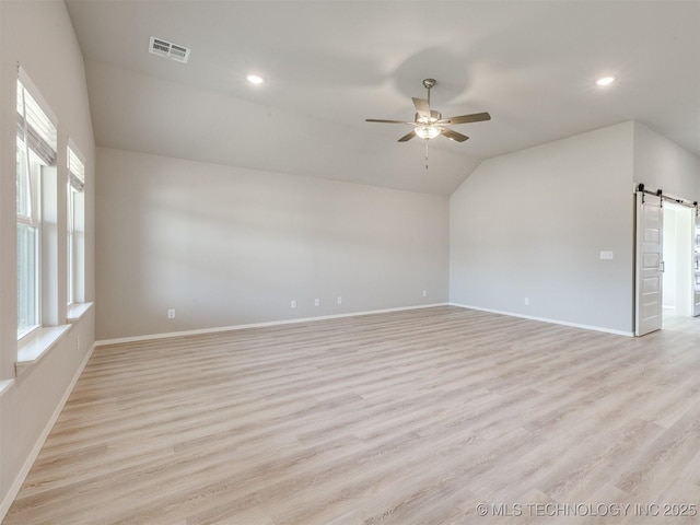 13402 E 124th St, Collinsville, OK 74021 - empty room with a barn door, a ceiling fan, lofted ceiling, baseboards, and light wood-style flooring