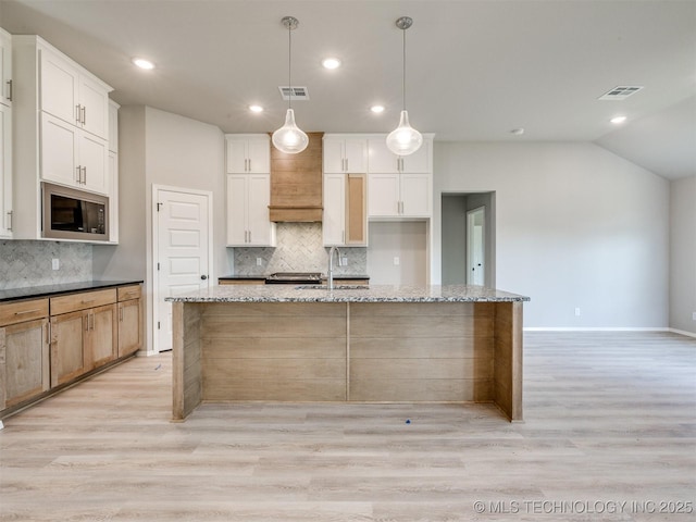 13402 E 124th St, Collinsville, OK 74021 - kitchen featuring built in microwave, decorative backsplash, light wood-type flooring, a center island with sink, and a sink