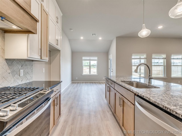13402 E 124th St, Collinsville, OK 74021 - kitchen with appliances with stainless steel finishes, a sink, light stone countertops, light wood finished floors, and tasteful backsplash