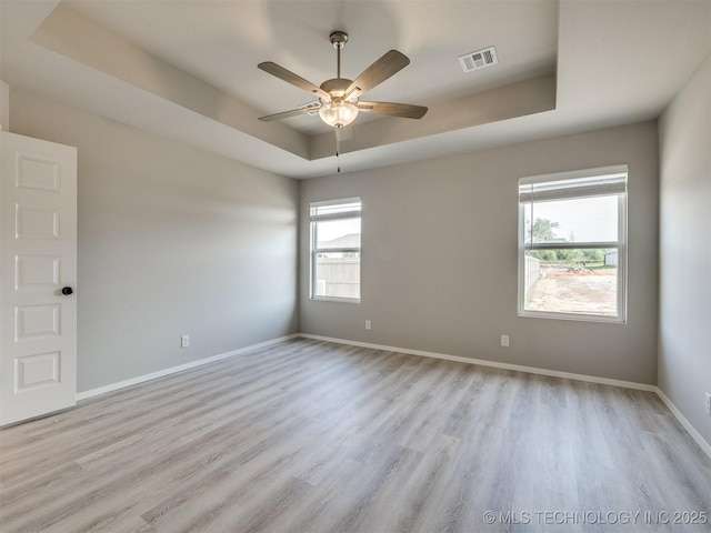 13402 E 124th St, Collinsville, OK 74021 - unfurnished room featuring a tray ceiling, plenty of natural light, wood finished floors, and a ceiling fan