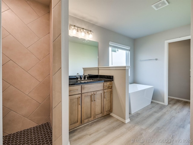 13402 E 124th St, Collinsville, OK 74021 - bathroom with wood finished floors, a freestanding bath, vanity, and baseboards
