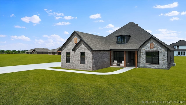 16321 E 101st St, Owasso, OK 74055 - view of front facade with a front yard, a shingled roof, brick siding, and stone siding