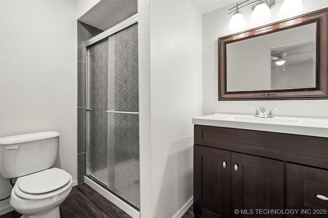 7911 E 66th St Unit 45H, Tulsa, OK 74133 - full bathroom featuring a stall shower, a textured wall, toilet, a ceiling fan, and vanity