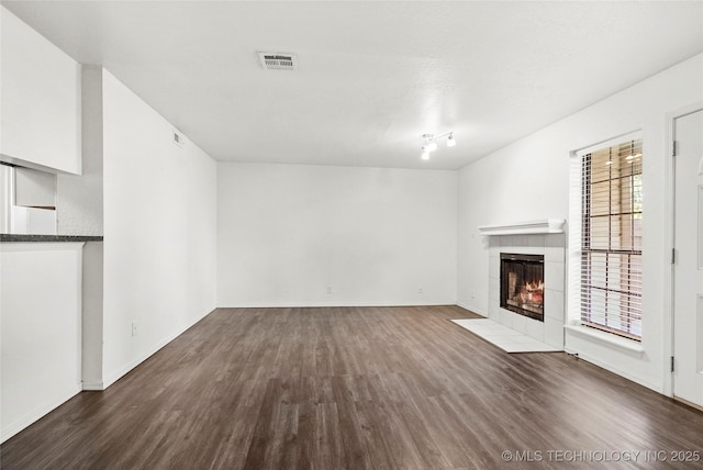 7911 E 66th St Unit 45H, Tulsa, OK 74133 - unfurnished living room with dark wood-style floors, a fireplace, and baseboards