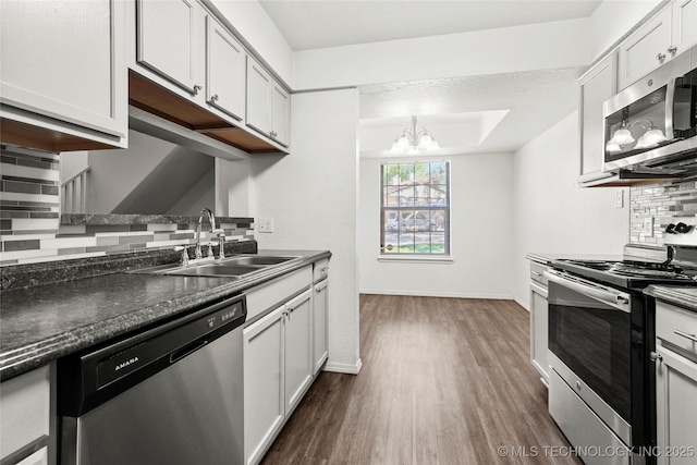 7911 E 66th St Unit 45H, Tulsa, OK 74133 - kitchen with stainless steel appliances, a sink, dark countertops, backsplash, and dark wood-style flooring