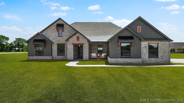 16306 E 102nd St, Owasso, OK 74055 - view of front of property with a front lawn, a standing seam roof, brick siding, a shingled roof, and metal roof