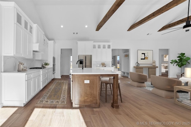 16306 E 102nd St, Owasso, OK 74055 - kitchen with high vaulted ceiling, light countertops, custom range hood, tasteful backsplash, and stainless steel refrigerator with ice dispenser