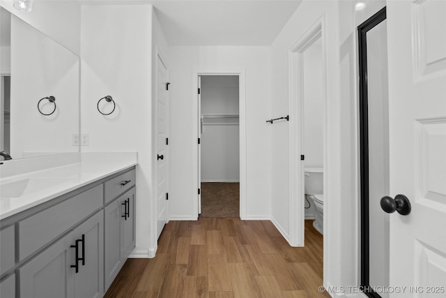 11412 E 93rd Pl, Owasso, OK 74055 - bathroom with wood finished floors, toilet, vanity, and baseboards