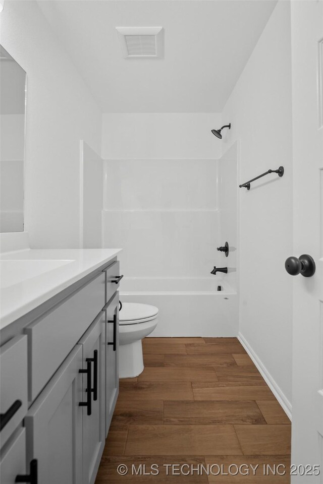 11412 E 93rd Pl, Owasso, OK 74055 - full bath featuring toilet, vanity, wood finished floors, and bathtub / shower combination