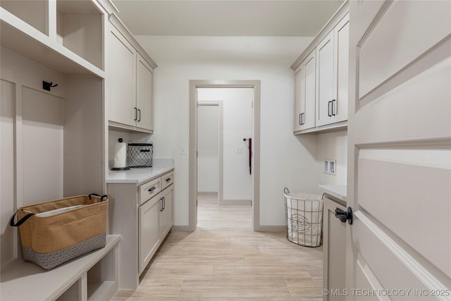 18258 S Clear Creek Ct, Claremore, OK 74017 - laundry area with cabinet space, hookup for a washing machine, light wood finished floors, and baseboards