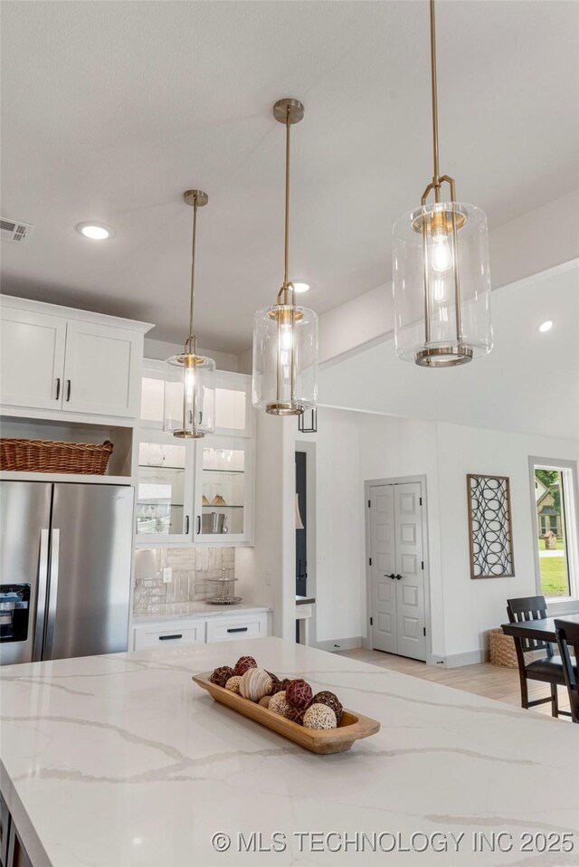 18258 S Clear Creek Ct, Claremore, OK 74017 - kitchen featuring recessed lighting, white cabinetry, light stone countertops, glass insert cabinets, and stainless steel refrigerator with ice dispenser