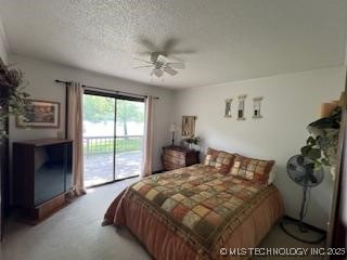 1417 Leisure Rd, Grove, OK 74344 - bedroom featuring access to exterior, a textured ceiling, and a ceiling fan