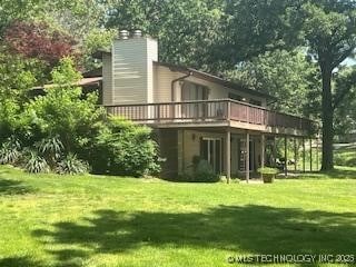 1417 Leisure Rd, Grove, OK 74344 - back of property featuring a deck, a yard, and a chimney