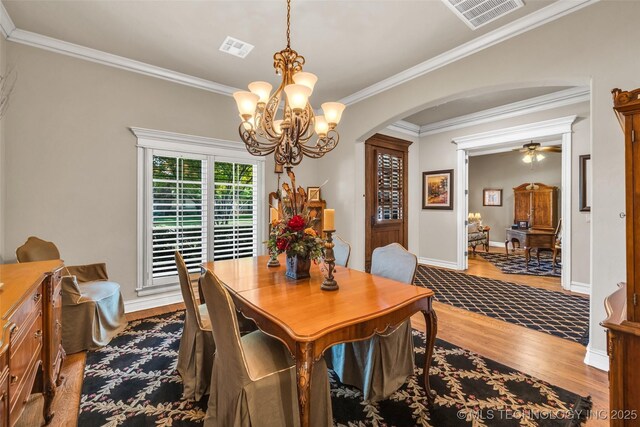 10942 S 93rd E Ave, Bixby, OK 74133 - dining room featuring arched walkways, wood finished floors, a chandelier, crown molding, and ceiling fan