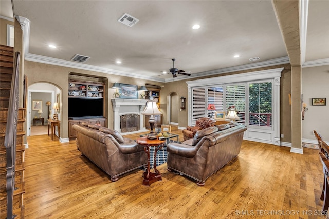 10942 S 93rd E Ave, Bixby, OK 74133 - living room featuring arched walkways, ornamental molding, a ceiling fan, baseboards, and light wood-style floors