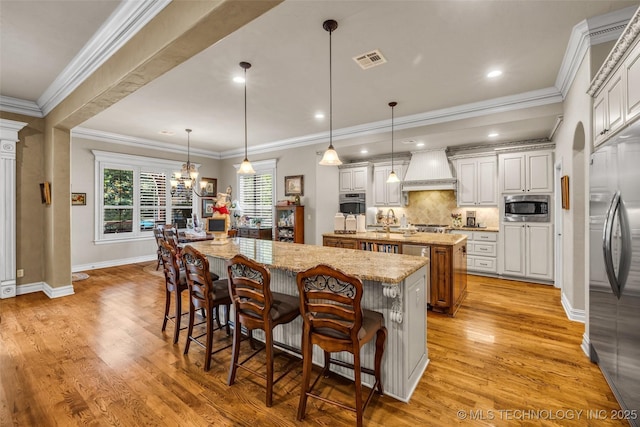 10942 S 93rd E Ave, Bixby, OK 74133 - kitchen featuring a large island, appliances with stainless steel finishes, custom exhaust hood, tasteful backsplash, and a breakfast bar