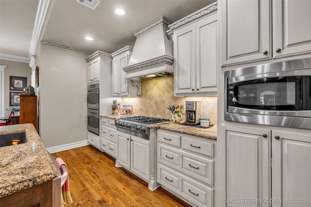 10942 S 93rd E Ave, Bixby, OK 74133 - kitchen featuring stainless steel appliances, premium range hood, backsplash, crown molding, and light wood finished floors