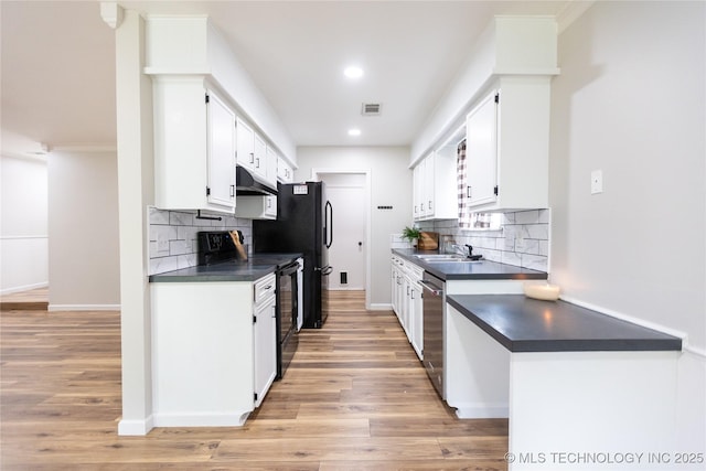 kitchen featuring under cabinet range hood, black electric range, dark countertops, stainless steel dishwasher, and recessed lighting