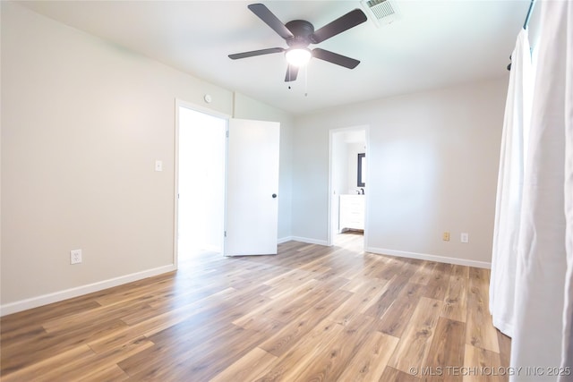 empty room with light wood finished floors, ceiling fan, baseboards, and vaulted ceiling