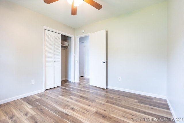 unfurnished bedroom with light wood-type flooring, a closet, and baseboards
