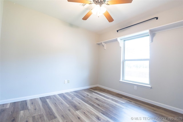 empty room with baseboards, a ceiling fan, and wood finished floors