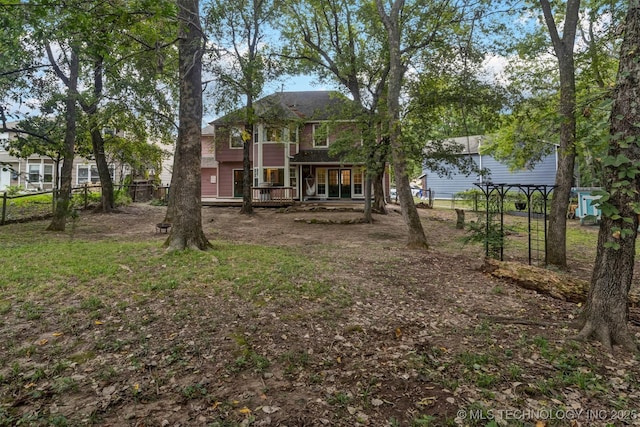 rear view of house with fence and a wooden deck