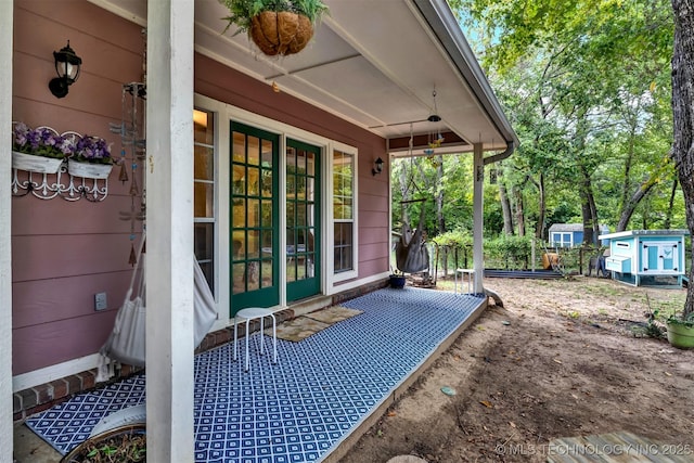 view of patio / terrace featuring a porch and a storage shed