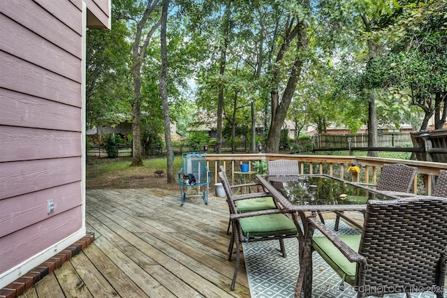 wooden deck featuring outdoor dining area and a fenced backyard