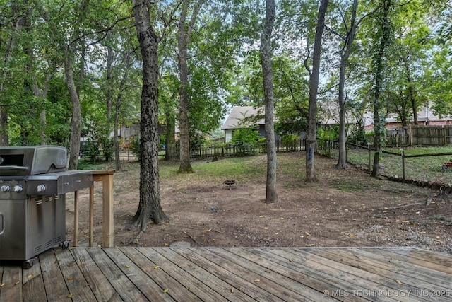 wooden deck with a fenced backyard and grilling area