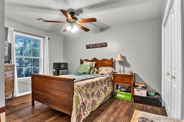 bedroom featuring wood finished floors, ceiling fan, a closet, and baseboards