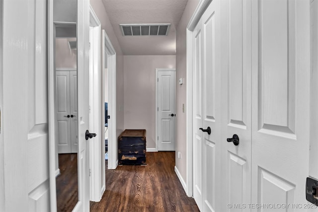 hallway featuring dark wood-style flooring and baseboards
