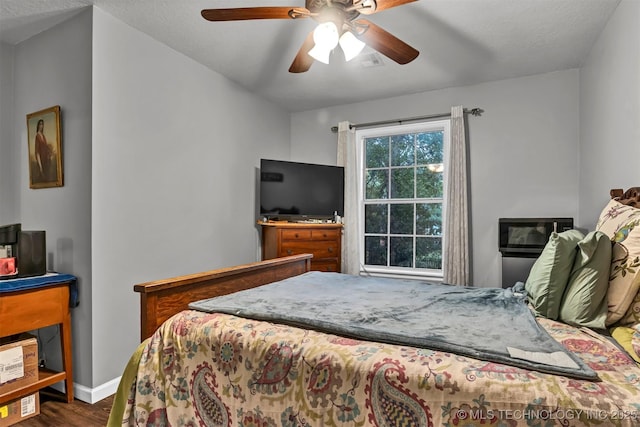 bedroom with dark wood-style flooring, baseboards, and ceiling fan