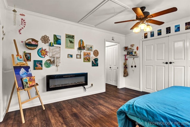 bedroom featuring attic access, wood finished floors, crown molding, baseboards, and a ceiling fan
