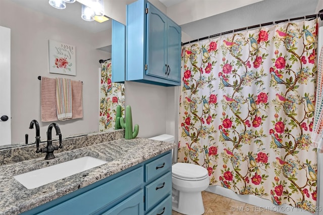 bathroom with a shower with shower curtain, vanity, toilet, and tile patterned floors